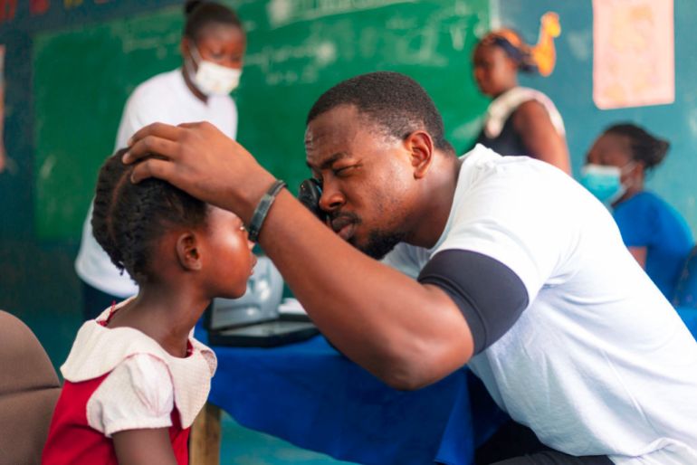 Health workers conduct eye tests for children as part of a community medical outreach in Ghana [Humserve Africa Foundation]