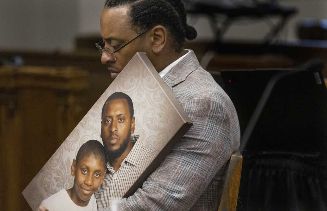 Antonio Mays Sr. holds a portrait of himself and his son.