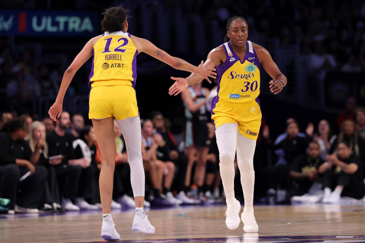 The Sparks' Nneka Ogwumike claps hands with Rae Burrell against the New York Liberty on July 28.