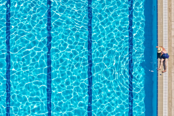 An aerial view of a woman sunbathing at the Dobrinja public pool in Sarajevo, Bosnia, Thursday, Aug. 6, 2026. (AP Photo/Armin Durgut)