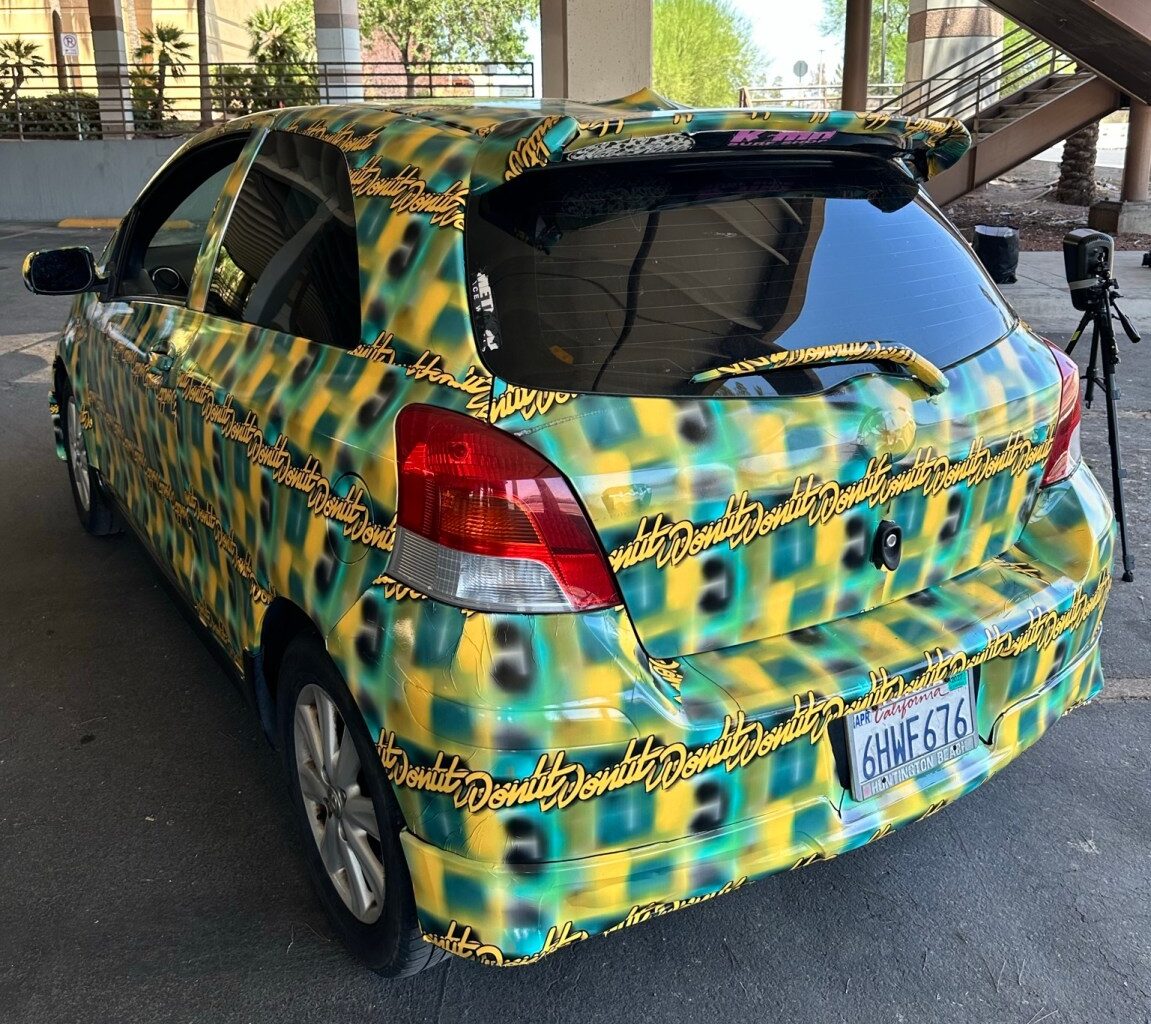 a photo of the toyota yaris covered in a pattern made by Bill Swearingen, as part of a test to see if it can defeat surveillance camera detection.