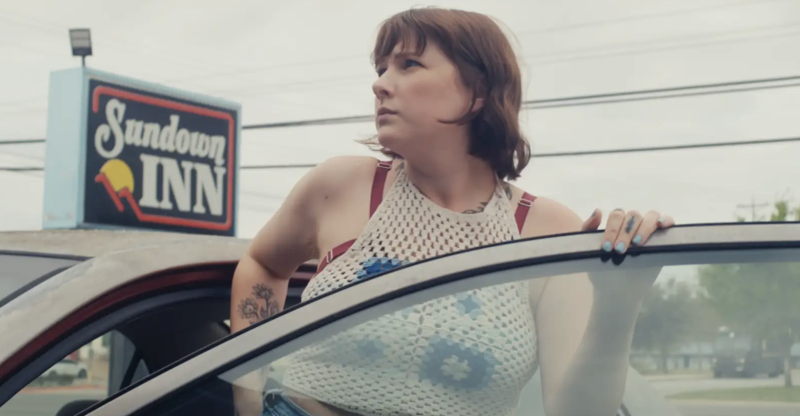 A woman gets out of her car outside of the Sundown Inn.