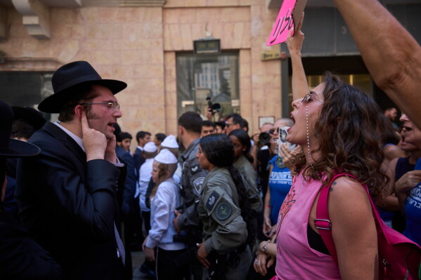 Ultra-Orthodox protesters demonstrate against a café operating on Shabbat, clashing with Israeli police and secular counter‑protesters supporting the café, in Jerusalem, Saturday, Aug. 8, 2026. (AP Photo/Ohad Zwigenberg)