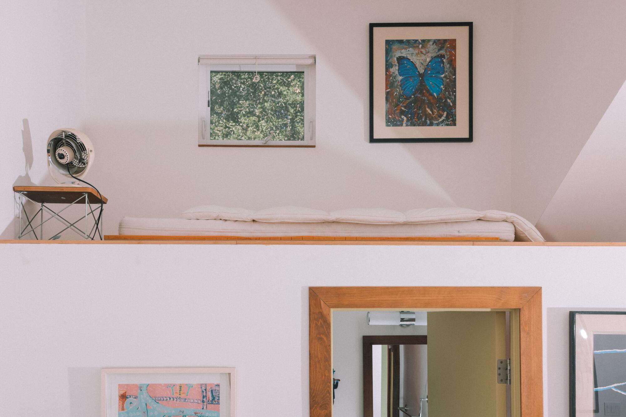A sleeping loft above a bathroom 
