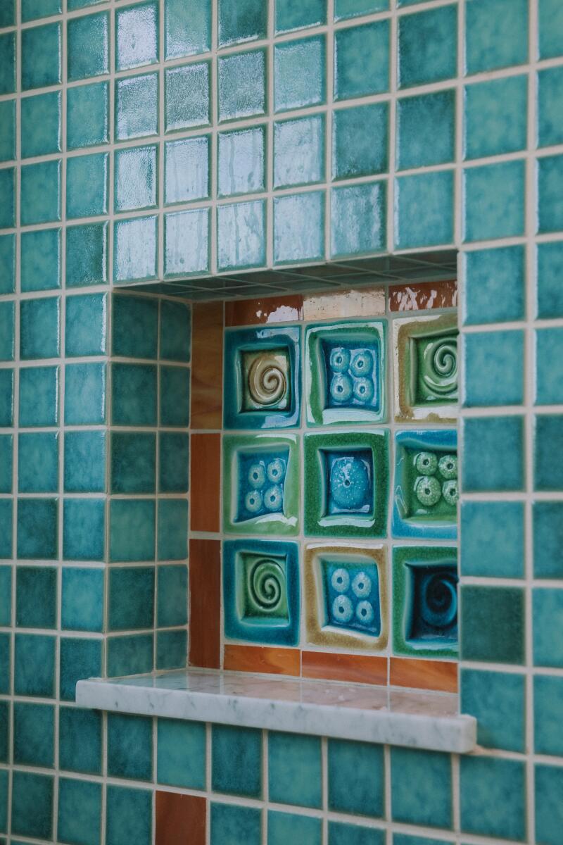 Bright blue tiles decorate the shower of the bathroom.