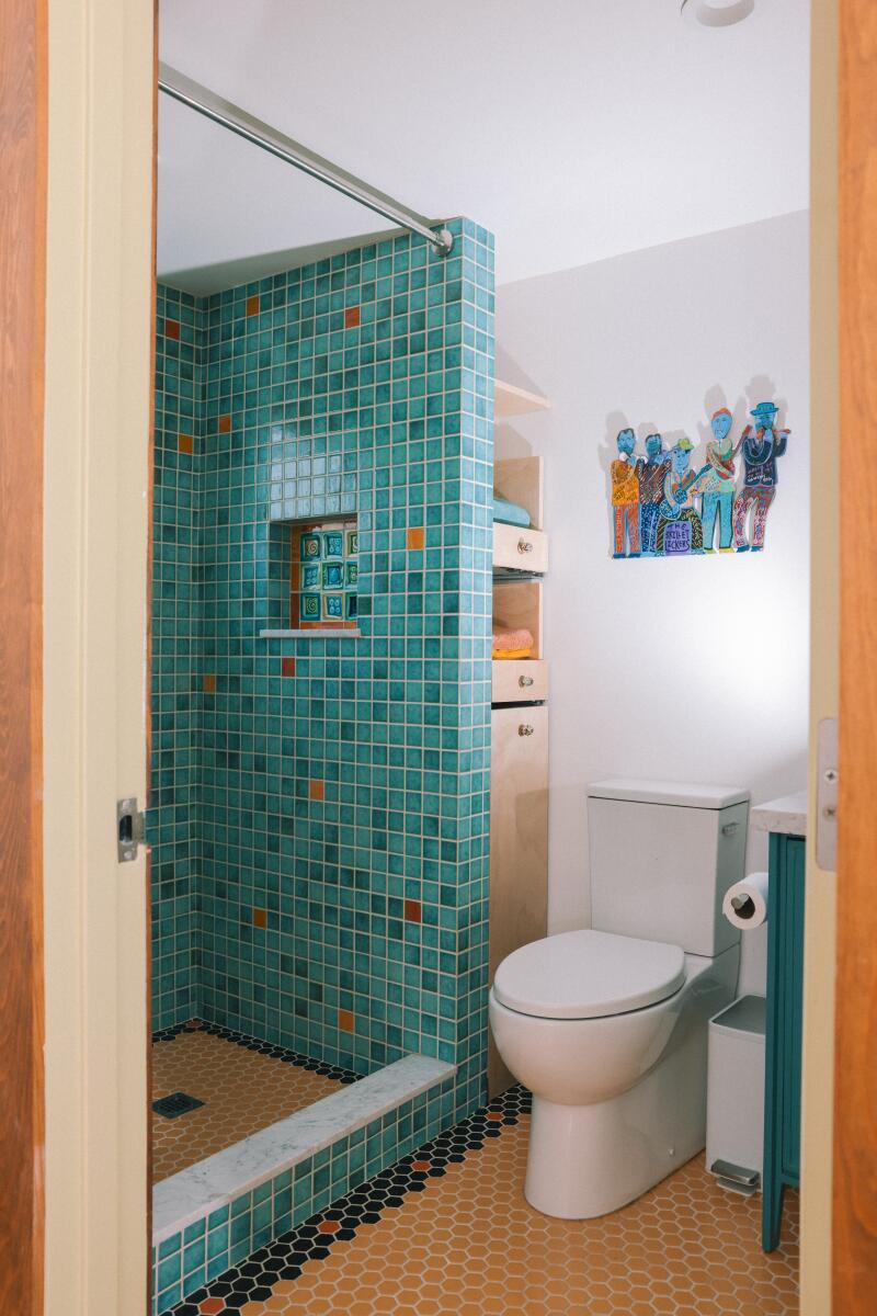 A bathroom with a shower covered in blue tile.