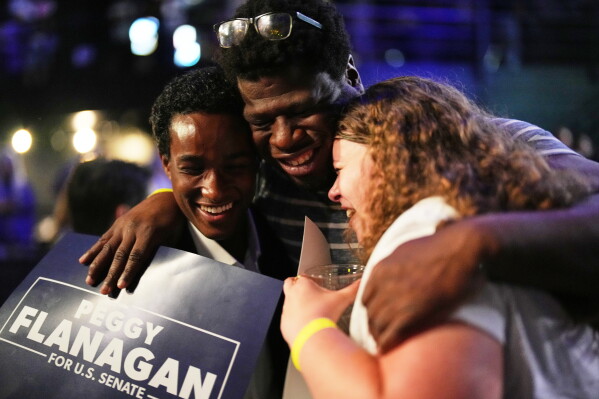 From left to right, Mohamed Mohamed, Tito Odenigbo and Maddie Lutterman embrace during an election night event for Minnesota Lt. Gov. Peggy Flanagan, a Democratic candidate for U.S. Senate, on Tuesday, Aug. 11, 2026, in Minneapolis. (AP Photo/Ellen Schmidt)