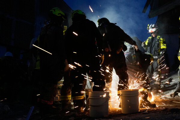 Rescue workers cut through debris as they attempt to rescue survivor Daniela Largo, who was trapped in the rubble the day after an earthquake struck Pereira, Colombia, Tuesday, Aug. 11, 2026. (AP Photo/Fernando Vergara)