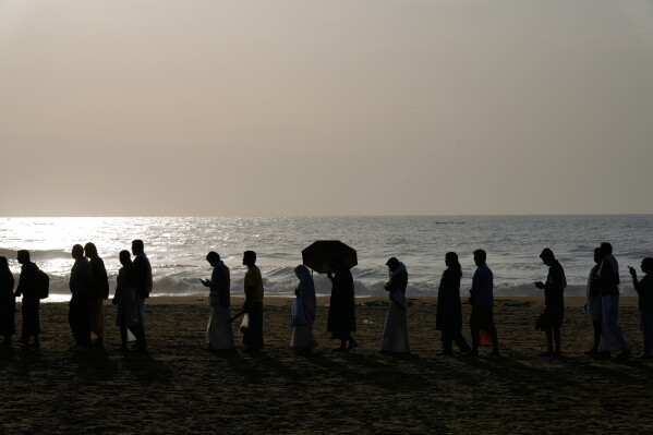 Hindu devotees line up to perform rituals for their ancestors and departed family members during Karkidaka Vavu, the new moon of the Malayalam month Karkidakam, on Marina Beach in Chennai, India, Wednesday, Aug. 12, 2026. (AP Photo/Mahesh Kumar A.)