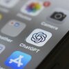 A cellphone screen is shown with the ChatGPT app icon in focus.