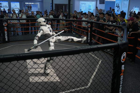 Visitors watch a humanoid robot perform during the World Robot Conference at the Beiren Yichuang International Convention and Exhibition Centre in Beijing, Wednesday, Aug. 19, 2026. (AP Photo/Andy Wong)
