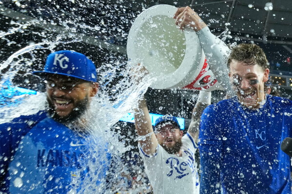 Kansas City Royals' Carlos Duran, left, and Bobby Witt Jr., right, are doused by Kyle Isbel, center, after their baseball game against the Athletics, Tuesday, Aug. 18, 2026, in Kansas City, Mo. (AP Photo/Charlie Riedel)