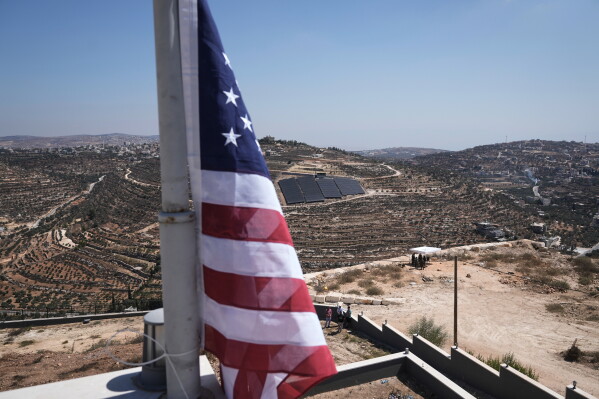 A U.S. flag hangs on the roof of Ohio-based Palestinian American Loui Ridi's home, which has been besieged by Israeli settlers for over a week, in the occupied West Bank village of Qusra, south of Nablus, Wednesday, Aug. 19, 2026. (AP Photo/Majdi Mohammed)