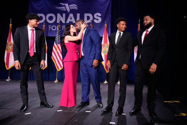 Florida Republican gubernatorial candidate Byron Donalds, center, is kissed by his wife Erika, while standing on stage with their children Darin, left, Damon, second from left, and Mason during a primary election party Tuesday, Aug. 18, 2026, in Orlando, Fla. (AP Photo/John Raoux)