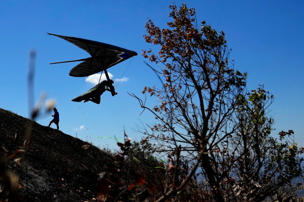 A pilot takes off in his hang glider from the Vale do Parana free-flight launch site during the 2026 Brasilia Open Hang Gliding near Brasilia, Brazil, Tuesday, Aug. 18, 2026. (AP Photo/Eraldo Peres)