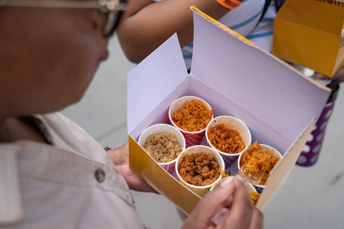 Shakesha Coleman tries some of the samples of Jollof at the festival at Union Market in Washington, D.C.