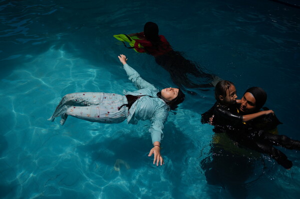 Rimas Abu Shalouf, 16, who lost both legs after being injured during the war between Israel and Hamas, receives swimming training from the Heal Palestine organization at a pool in Khan Younis, Gaza Strip, Wednesday, Aug. 19, 2026. (AP Photo/Abdel Kareem Hana)