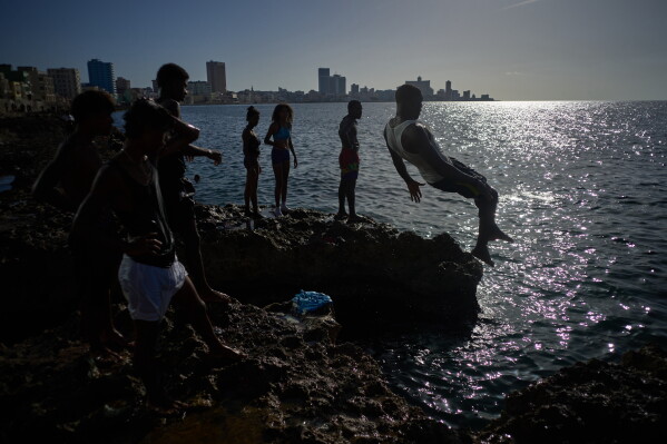 A bather jumps into the sea in Havana, Wednesday, Aug. 19, 2026. (AP Photo/Ramon Espinosa)
