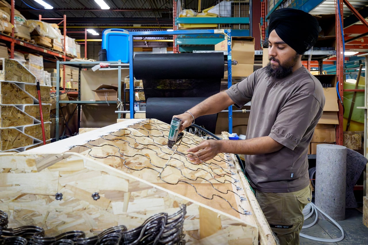A man assembling a sofa in a factory.