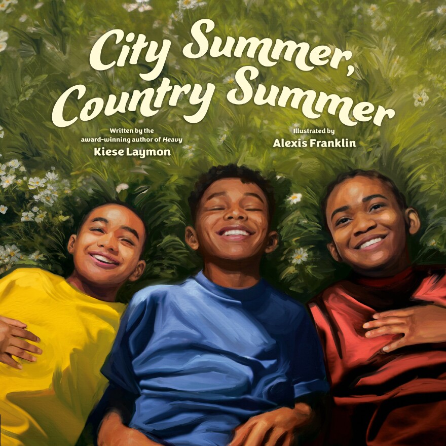 The cover of "City Summer, Country Summer," a children's book written by Kiese Laymon and illustrated by Alexis Franklin. Three Black boys lie in a field grass and daisies, wearing yellow, blue, and red t-shirts. They're laughing and relaxed.
