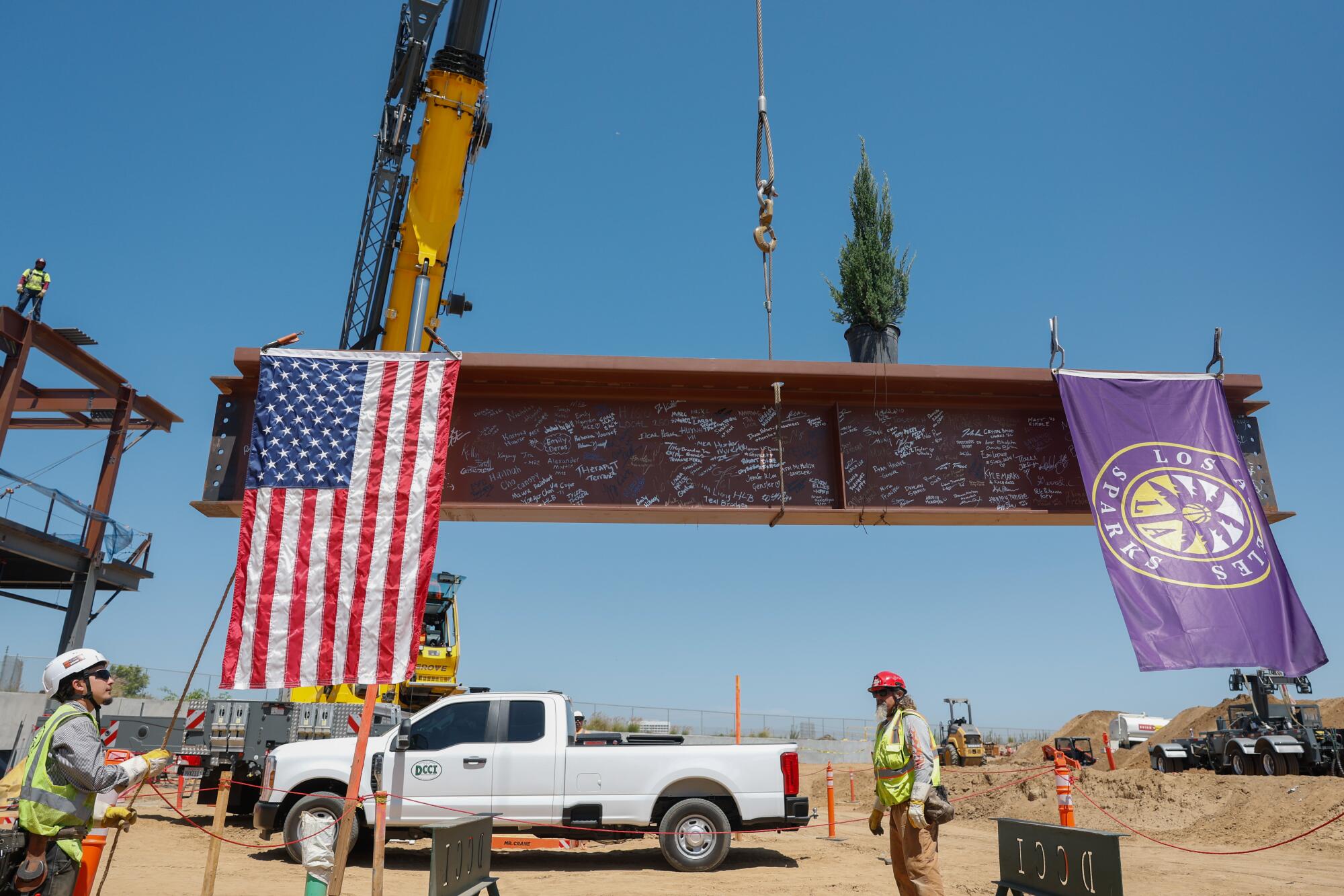 A steel beam is raised as the final structuarl piece of the Sparks' $150-million training facility in El Segundo.