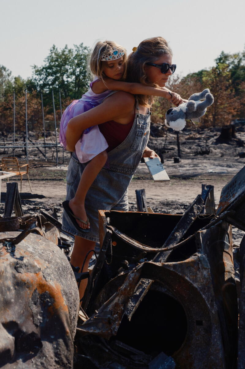 Marie Raturat Bouny, 34, and her daughter Noa, 6, take in the ruins of their house after a wildfire