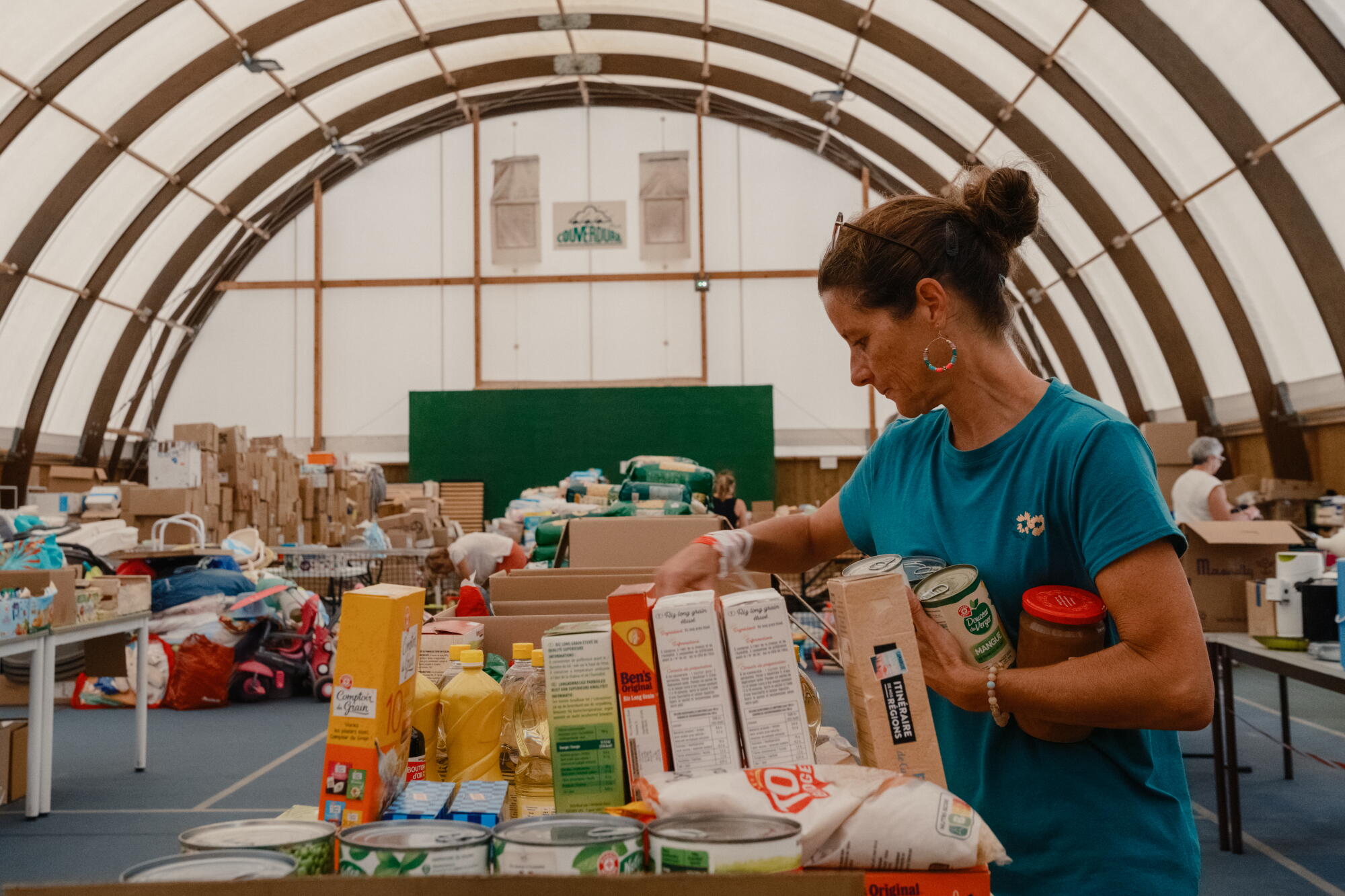 A woman sorts donated food at a relief center.