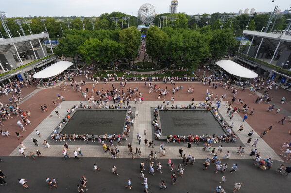 Spectators walk around the grounds of the USTA Billie Jean King National Tennis Center during the first round of the U.S. Open tennis championships Sunday, Aug. 30, 2026, in New York. (AP Photo/Frank Franklin II)
