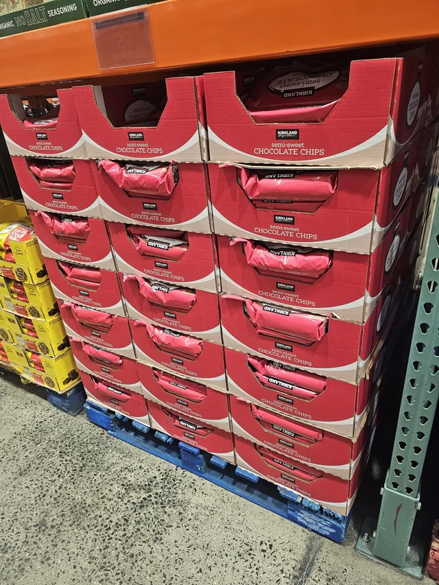 A large display of Kirkland semi-sweet chocolate chips in red boxes at Costco.