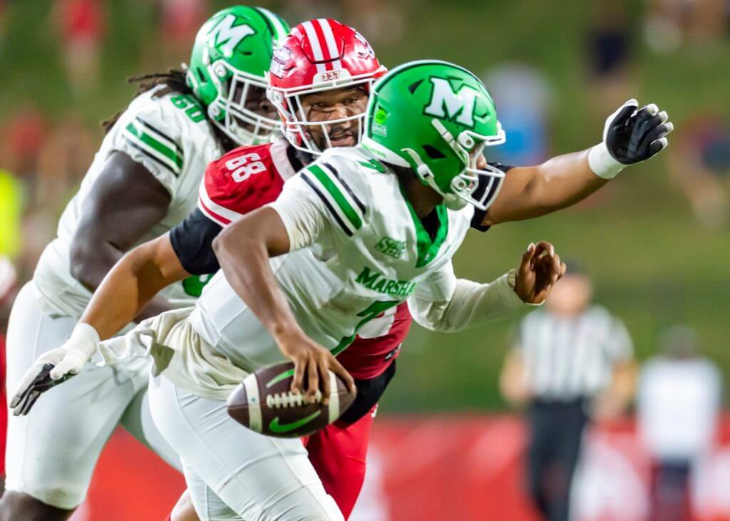 Carlos Del Rio-Wilson holds the football and tries to run away from a Louisiana defender