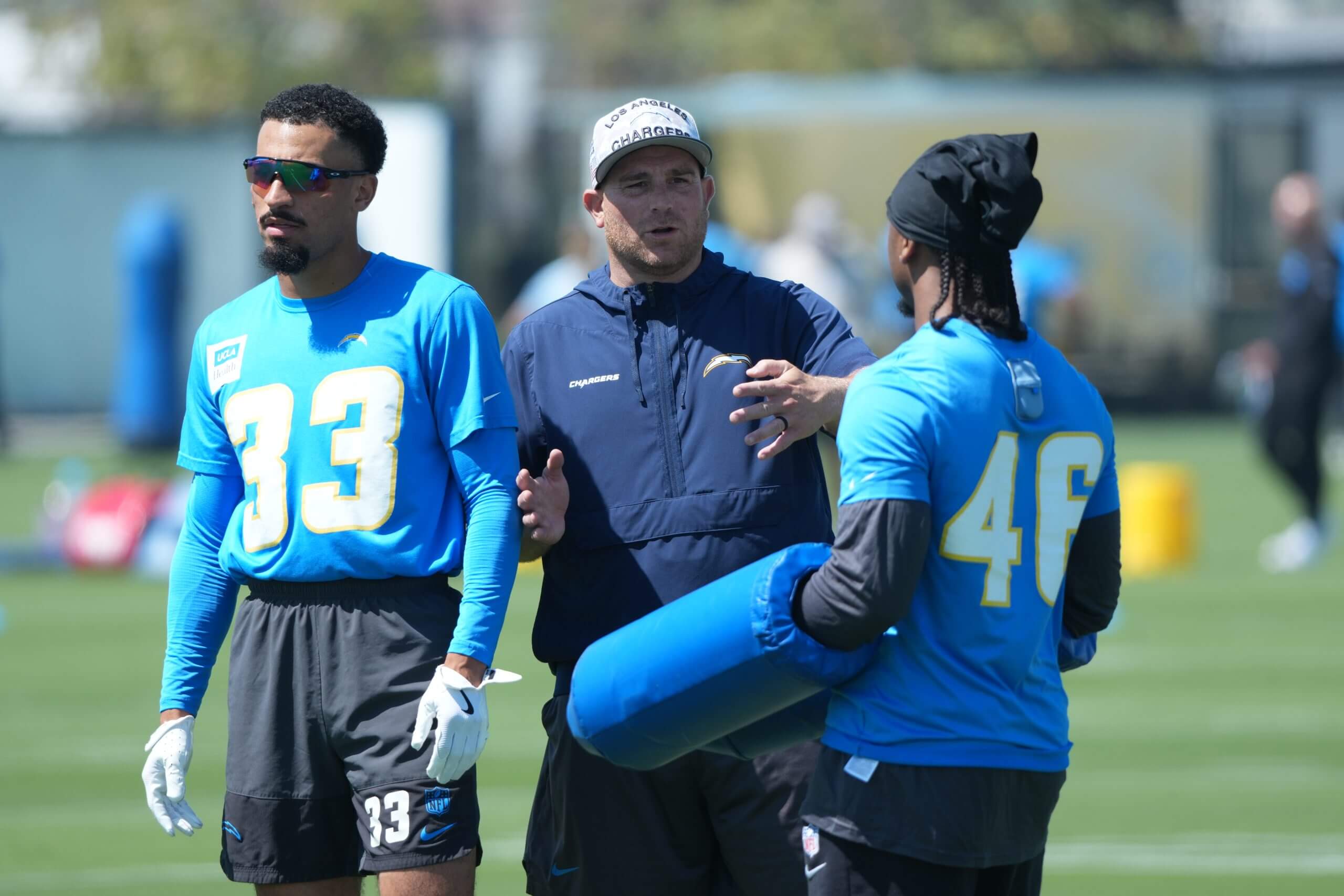 Los Angeles Chargers assistant special teams coach Chris Gould talks with cornerback Nikko Reed (46) and defensive back Deane Leonard (33) during offseason workouts at The Bolt.