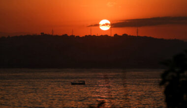 Fishermen row their boat as they head out to fish in the Mediterranean Sea at sunrise off Tyre