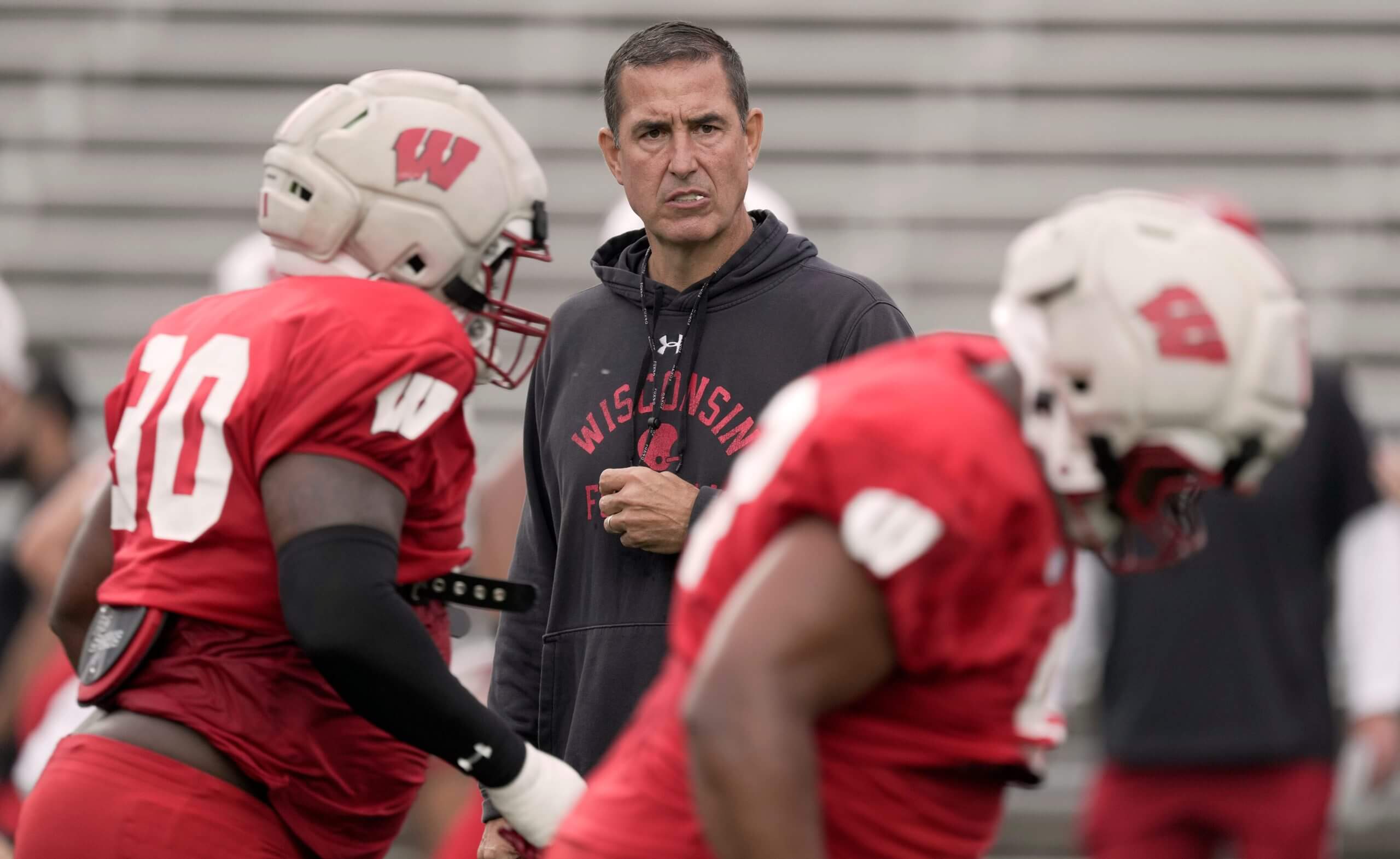Luke Fickell holds a whistle while watching Wisconsin players practice
