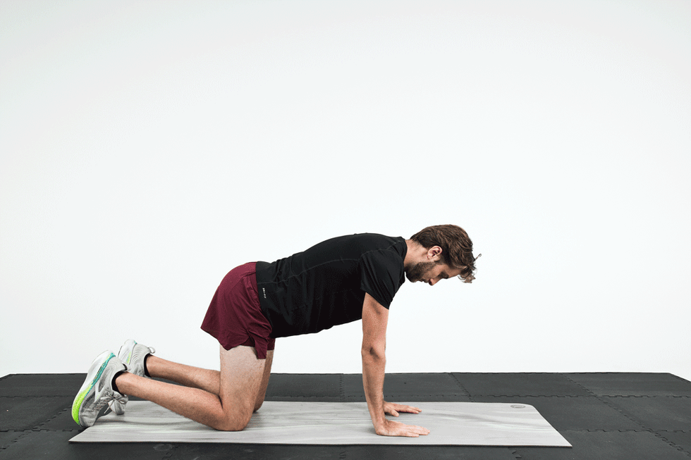A person demonstrating an exercise on a yoga mat in a fitness studio setting. A person demonstrating an exercise on a yoga mat in a fitness studio setting.