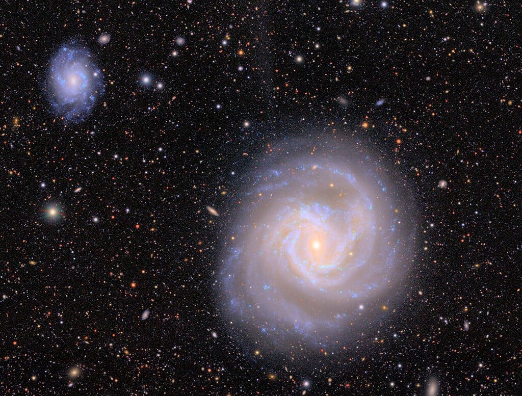 Image of a large iridescent white galaxy against a starry background. Vera Rubin Observatory Photo.