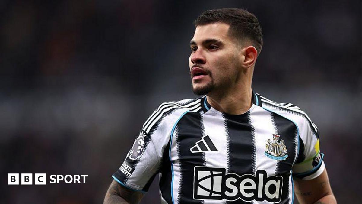 Bruno Guimaraes is looking on in a black and white Newcastle shirt