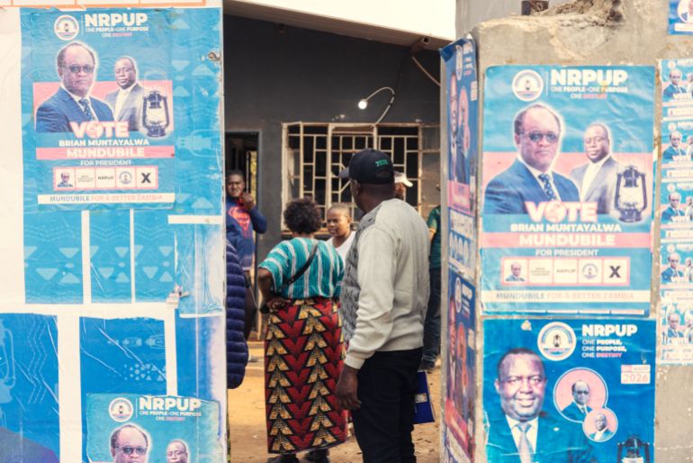 People stand inside an opposition election campaign office displaying the posters of Brian Muntayalwa Mundubile in Lusaka on August 10, 2026 [Gianluigi Guercia/AFP]