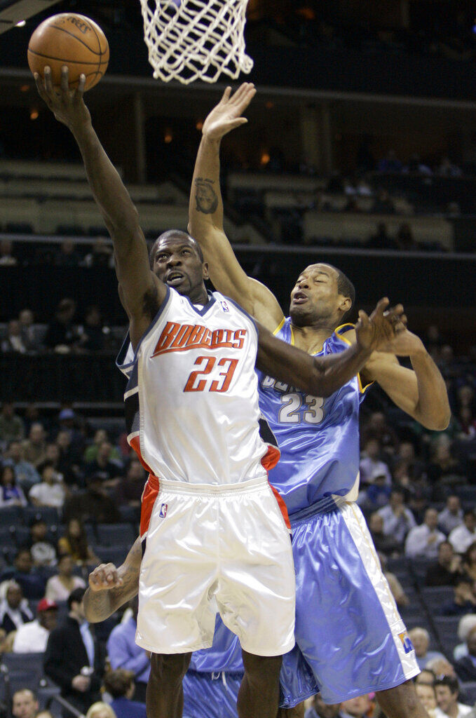 Charlotte Bobcats guard Jason Richardson, left, drives past Denver Nuggets center Marcus Camby, right, during an NBA basketball game in Charlotte, N.C., Monday, Jan. 14, 2008. (AP Photo/Chuck Burton)