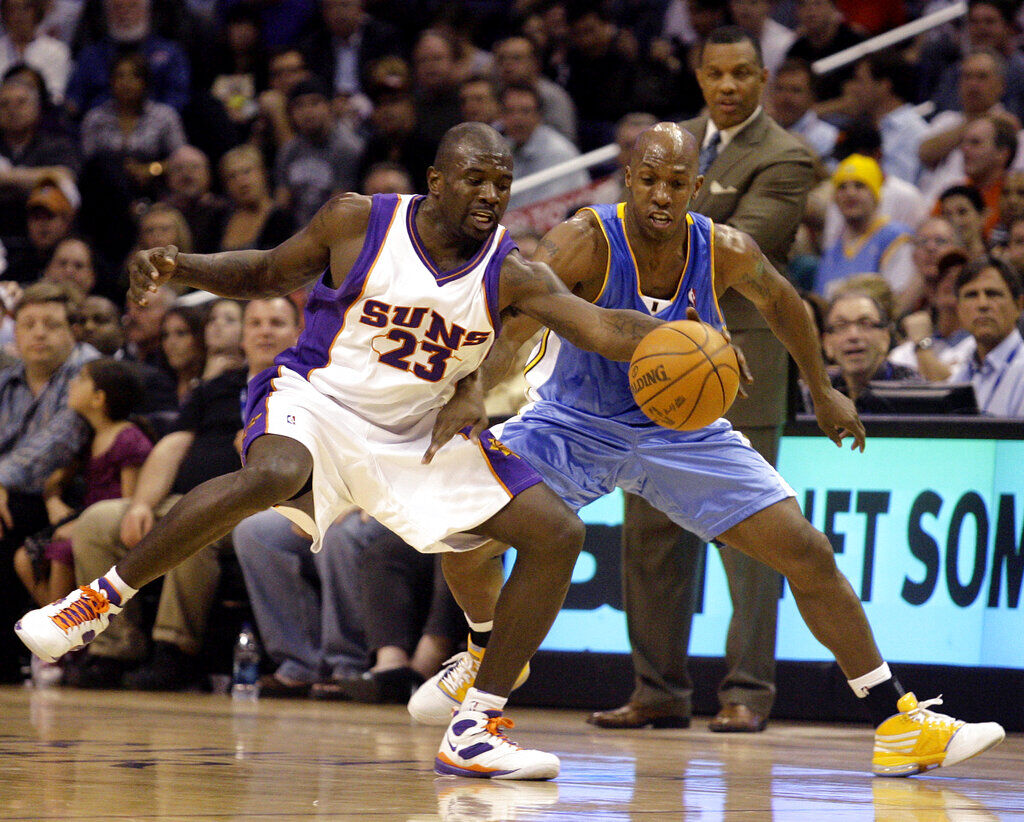 Phoenix Suns guard Jason Richardson, left, and Denver Nuggets guard Chauncey Billups, right, battle for a loose ball in the first quarter of an NBA basketball game Monday, March 23, 2009, in Phoenix. (AP Photo/Paul Connors)