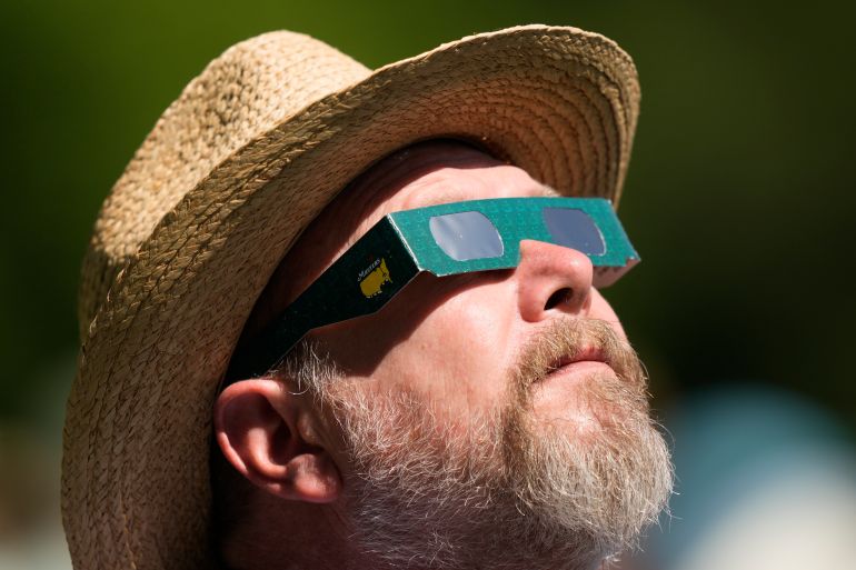 A man looks up at the sun during a solar eclipse at the Augusta National Golf Club in the US state of Georgia on April 7, 2024