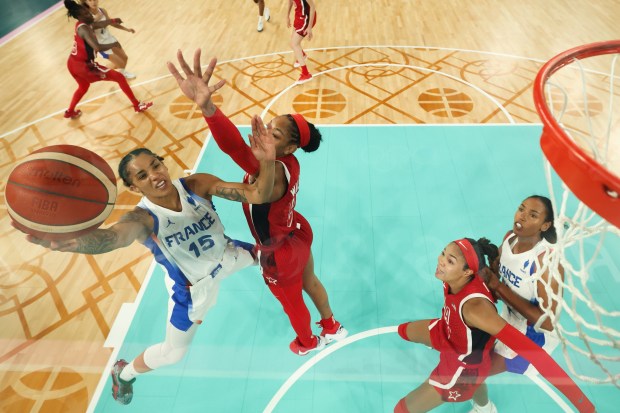 Gabby Williams, left, (15), of France, shoots for goal as United States' A'ja Wilson (9) attempts to block during a women's gold medal basketball game between the United States and France at Bercy Arena at the 2024 Summer Olympics, Sunday, Aug. 11, 2024, in Paris, France. (Gregory Shamus/Pool Photo via AP)
