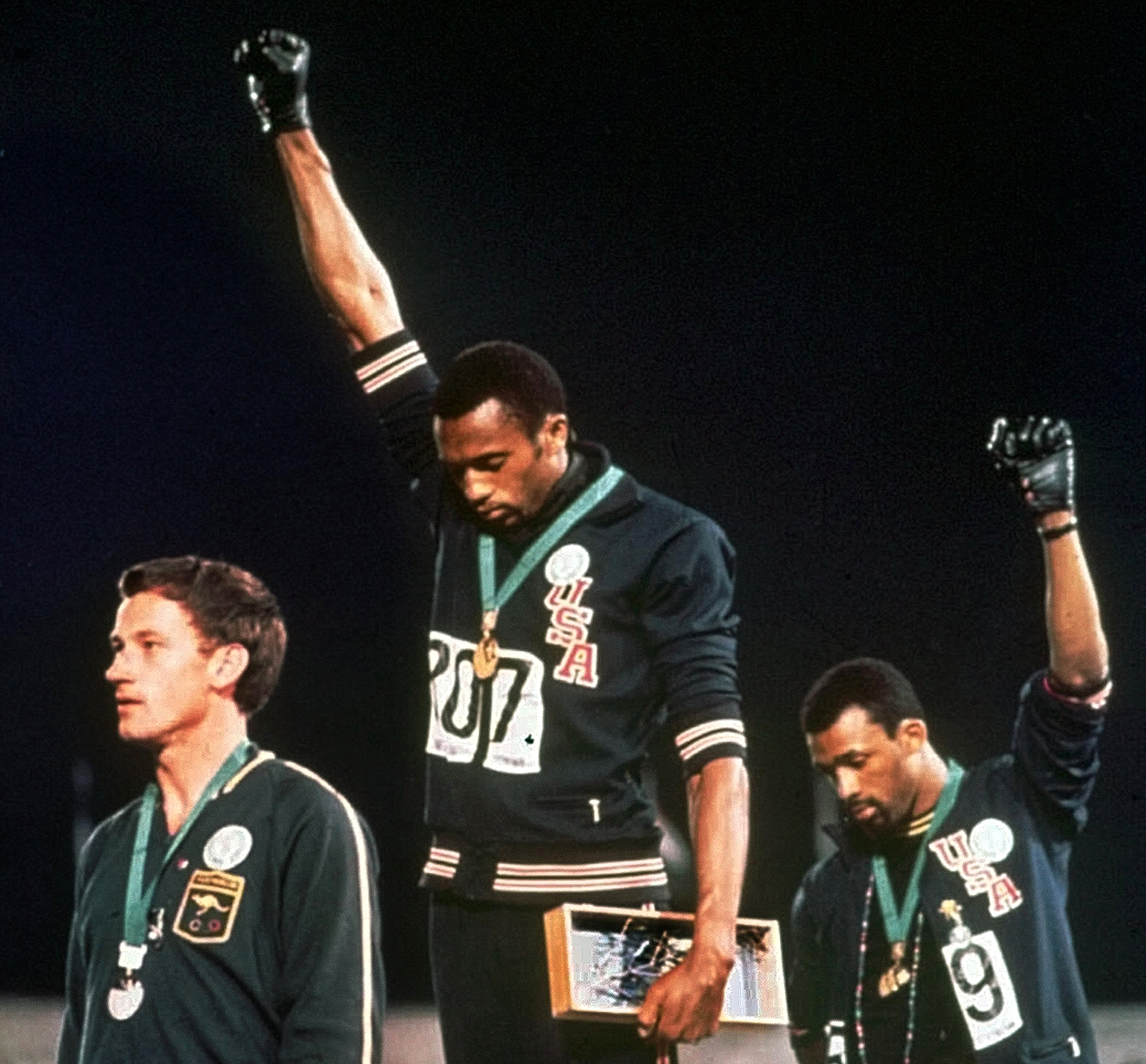 Americans Tommie Smith, center, and John Carlos raise their gloved fists in a human rights protest at the 1968 Summer Olympics in Mexico City. (Associated Press, File)