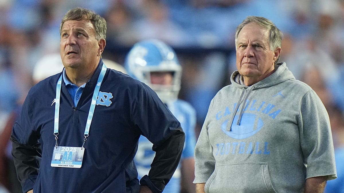 Bill Belichick and Michael Lombardi stand on the sideline