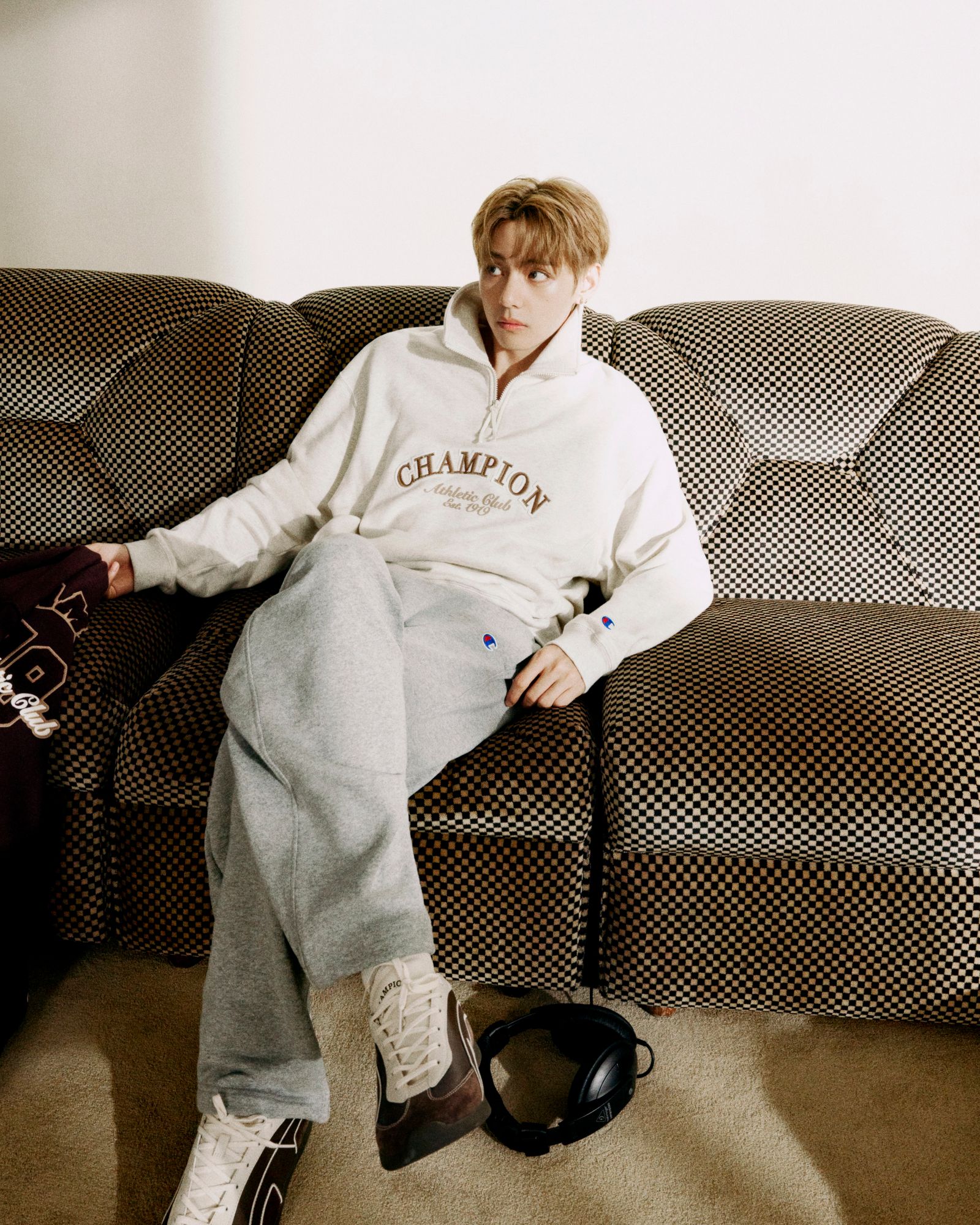 Image may contain Jungkook Couch Furniture Person Sitting Clothing Pants Teen Home Decor Face and Head