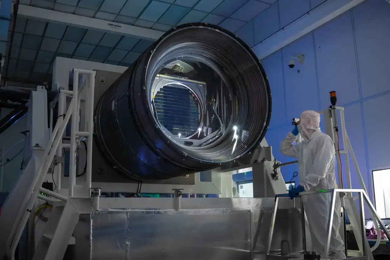 The large camera of the Vera C. Rubin Observatory pictured beside a worker.