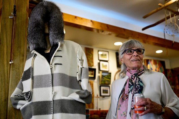 Artist Charmaine Nicholson stands next to her handmade coat on display at Western Stars Gallery in Lyons on July 16. (Joel Solis/Staff Photographer)