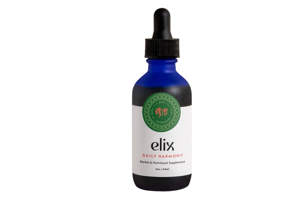 A blue apothecary bottle with the words Elix Daily Harmony