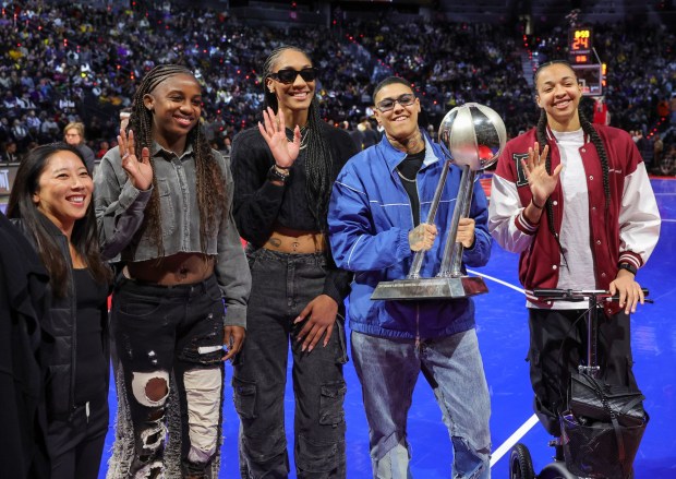 LAS VEGAS, NEVADA - DECEMBER 09: (L-R) First assistant coach Natalie Nakase, Jackie Young, A'ja Wilson, Kierstan Bell and Kiah Stokes of the Las Vegas Aces pose with the WNBA championship trophy during a break in the second quarter of the championship game of the inaugural NBA In-Season Tournament between the Indiana Pacers and the Los Angeles Lakers at T-Mobile Arena on December 09, 2023 in Las Vegas, Nevada. The Lakers defeated the Pacers 123-109. NOTE TO USER: User expressly acknowledges and agrees that, by downloading and or using this photograph, User is consenting to the terms and conditions of the Getty Images License Agreement. (Photo by Ethan Miller/Getty Images)