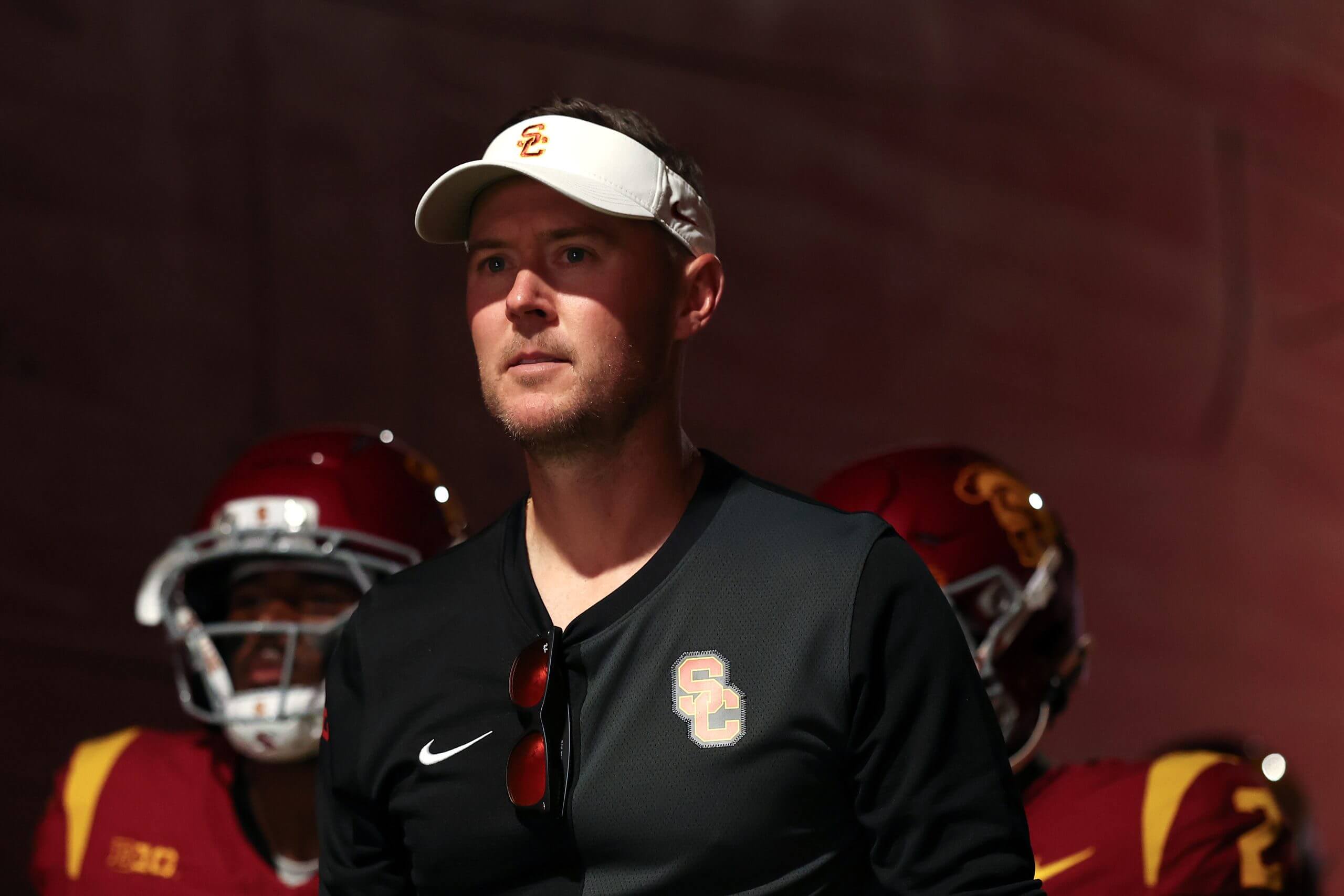 Lincoln Riley looks forward while walking out of the tunnel in front of USC players