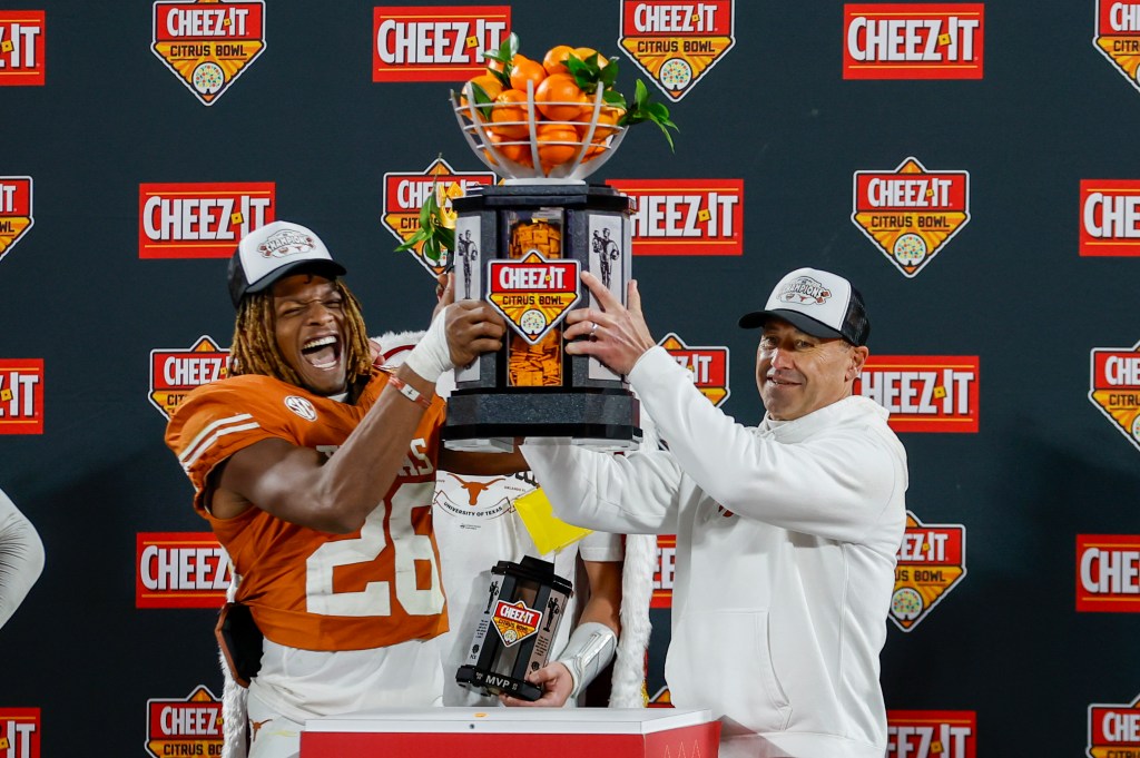 Texas Longhorns linebacker Ty'Anthony Smith (26) and head coach Steve Sarkisian (r.) raise the trophy after winning the Cheez-It Citrus Bowl on Dec. 31, 2025.